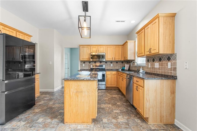 kitchen featuring visible vents, a kitchen island, stone finish floor, stainless steel appliances, and a sink