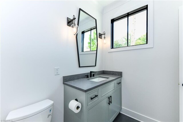half bathroom with vanity and toilet