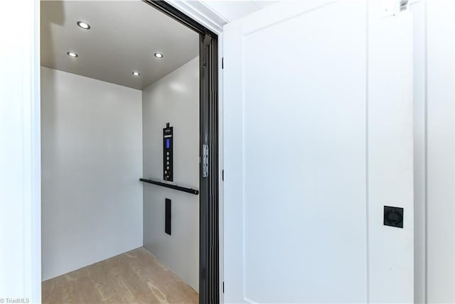 hallway with recessed lighting and elevator
