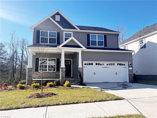 craftsman house with a garage, concrete driveway, and a front lawn