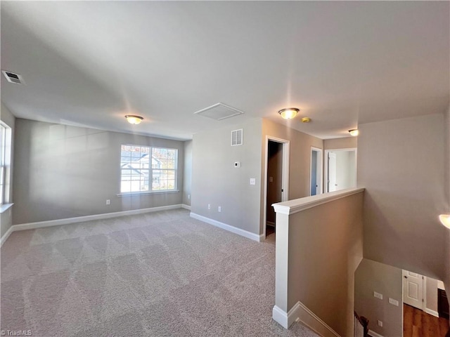 empty room featuring visible vents, carpet flooring, and baseboards