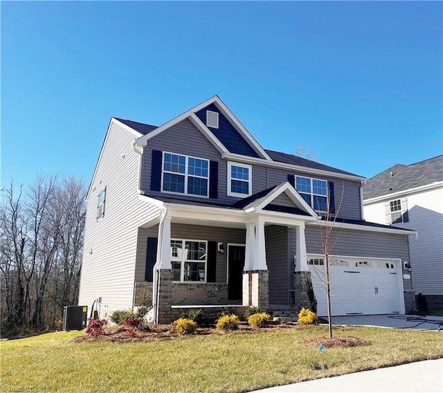 craftsman-style home with covered porch, a garage, cooling unit, and a front lawn