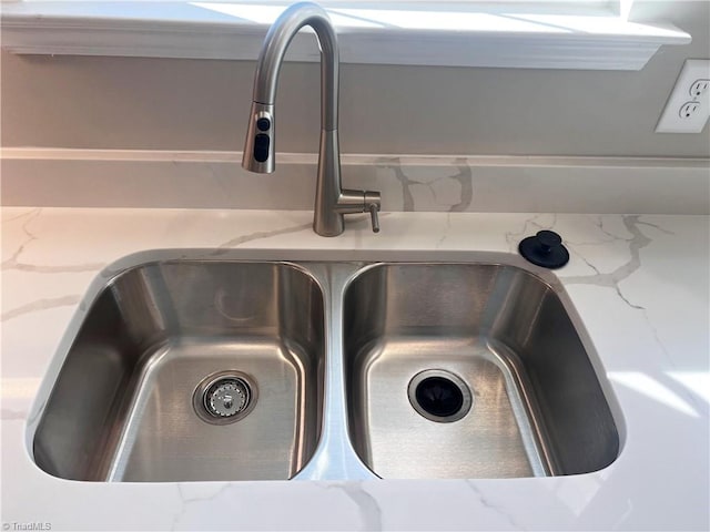 interior details featuring light stone countertops and a sink