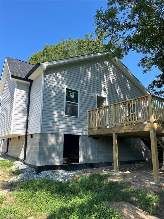 rear view of property featuring a wooden deck