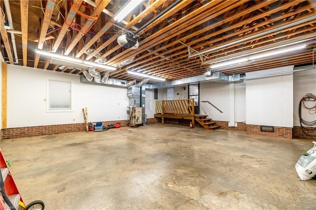 basement with heating unit and brick wall