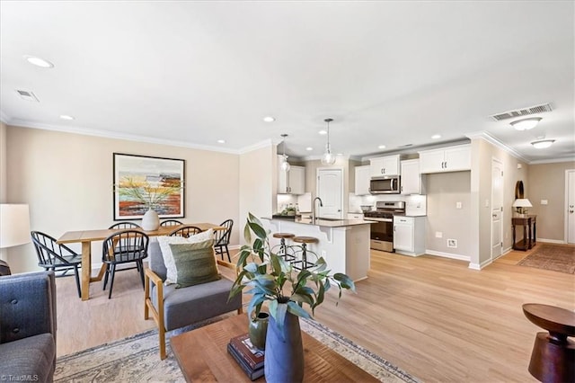 living area featuring crown molding, baseboards, and visible vents