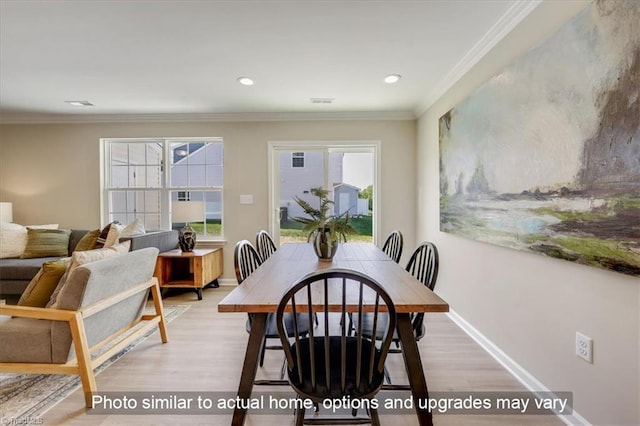 dining space with baseboards, ornamental molding, and light wood-style floors