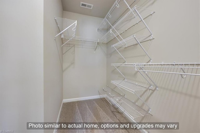 spacious closet featuring visible vents and carpet floors
