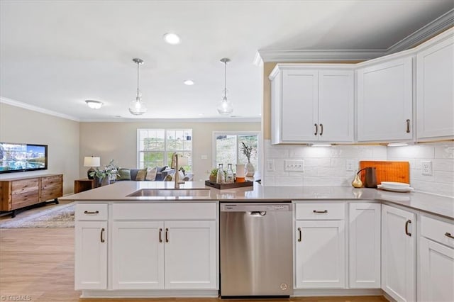 kitchen featuring white cabinets, a sink, a peninsula, stainless steel dishwasher, and ornamental molding