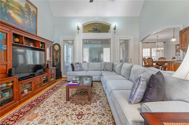 living room featuring high vaulted ceiling and an inviting chandelier