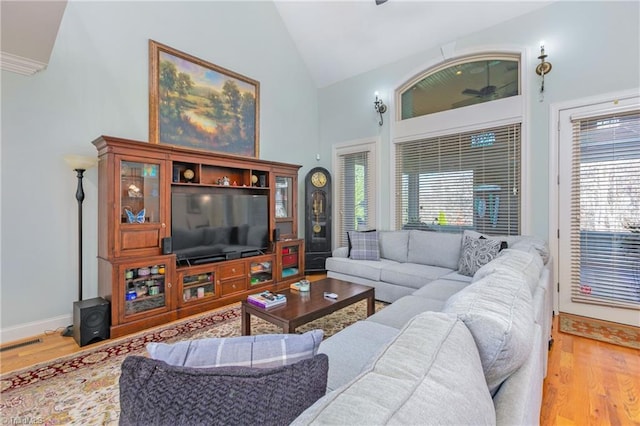 living room with high vaulted ceiling and hardwood / wood-style flooring