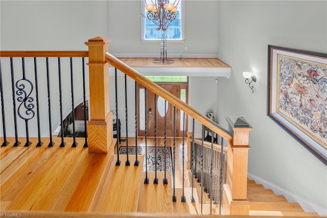 staircase featuring hardwood / wood-style floors and a notable chandelier