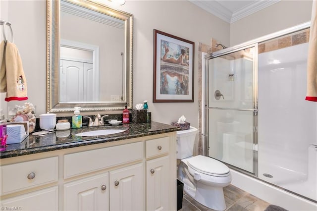 bathroom with vanity, toilet, a shower with door, and ornamental molding