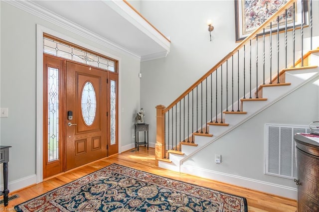 foyer featuring hardwood / wood-style flooring and crown molding