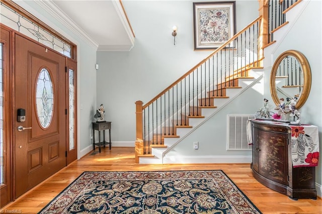 entryway featuring crown molding and light hardwood / wood-style flooring