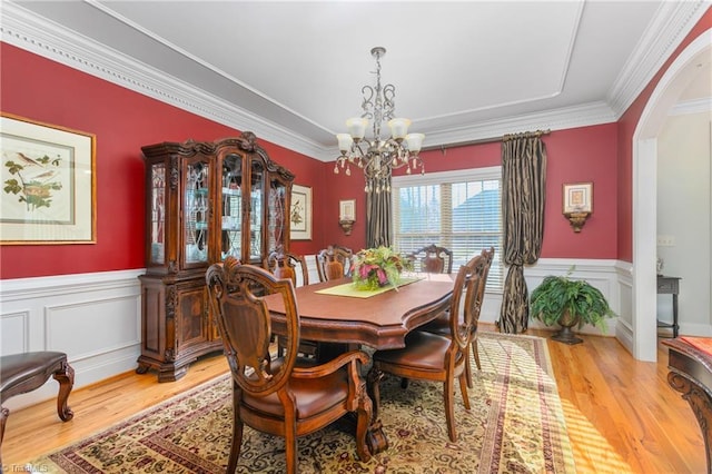 dining space featuring a chandelier, ornamental molding, and hardwood / wood-style flooring