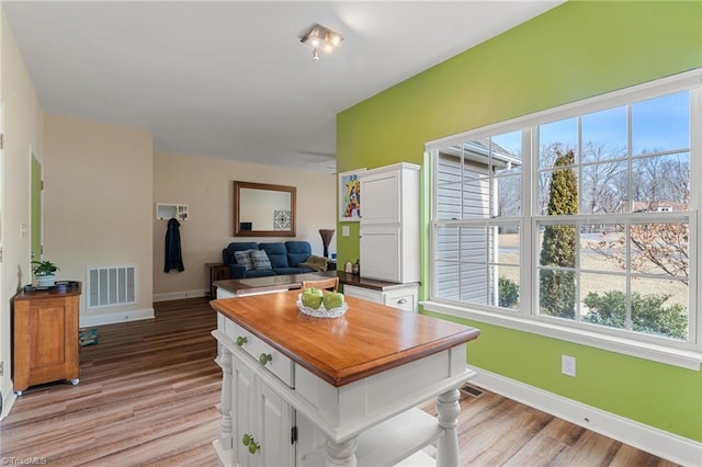 kitchen with light hardwood / wood-style flooring and white cabinets