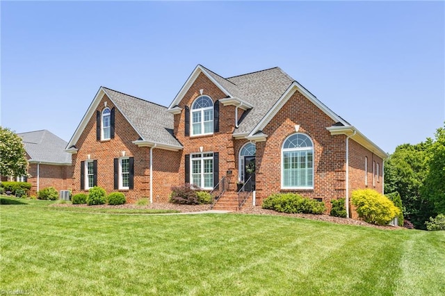 153 Montauk Ct, Clemmons, NC 27012 - view of front facade with brick siding, a front yard, and a shingled roof
