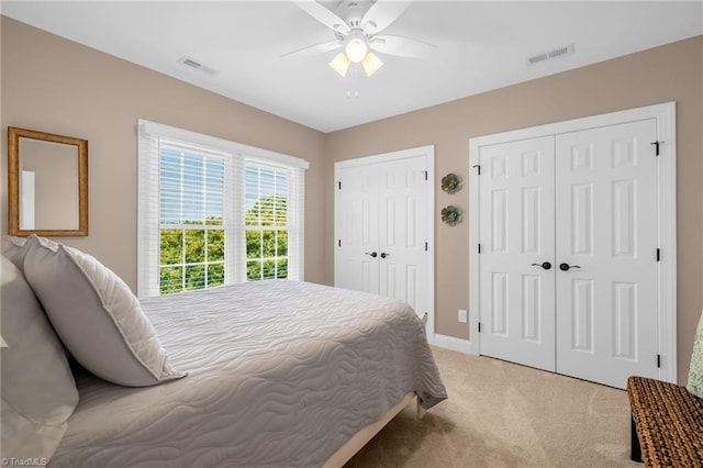 153 Montauk Ct, Clemmons, NC 27012 - bedroom featuring two closets, light carpet, and ceiling fan