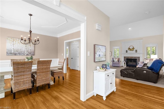 153 Montauk Ct, Clemmons, NC 27012 - dining area with light wood-style flooring, a chandelier, a fireplace, and ornamental molding