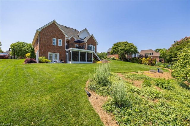 153 Montauk Ct, Clemmons, NC 27012 - rear view of house featuring a sunroom, a yard, brick siding, and stairs