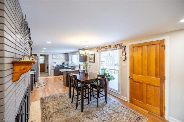 144 Collins Rd, Sparta, NC 28675 - dining room with a chandelier, sink, and light hardwood / wood-style flooring