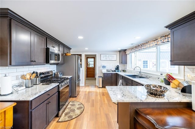 144 Collins Rd, Sparta, NC 28675 - kitchen with sink, tasteful backsplash, light hardwood / wood-style floors, light stone counters, and stainless steel appliances