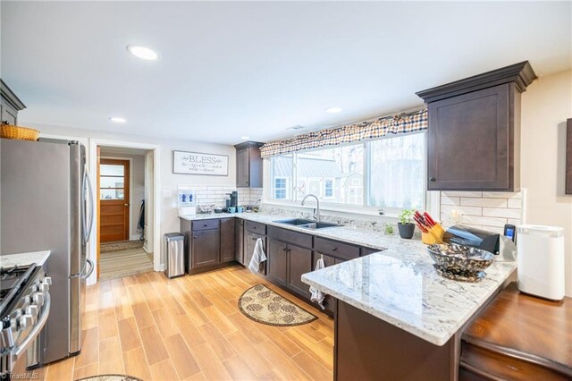 144 Collins Rd, Sparta, NC 28675 - kitchen with kitchen peninsula, decorative backsplash, light stone countertops, and sink