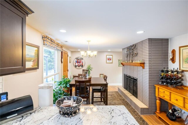 144 Collins Rd, Sparta, NC 28675 - dining space with hardwood / wood-style floors, a notable chandelier, and a brick fireplace