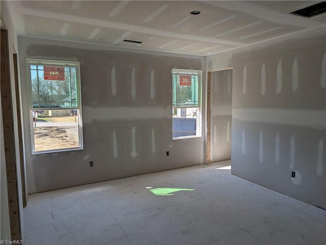 unfurnished room with plenty of natural light and visible vents