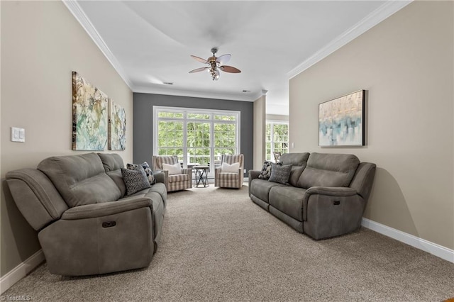 carpeted living area featuring crown molding, a ceiling fan, and baseboards