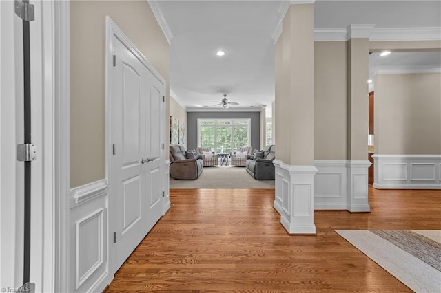 corridor featuring ornamental molding, wainscoting, recessed lighting, and wood finished floors