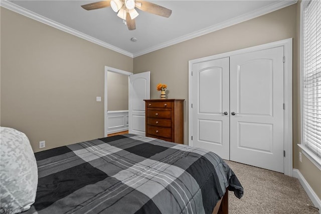bedroom with carpet floors, a ceiling fan, ornamental molding, and a closet
