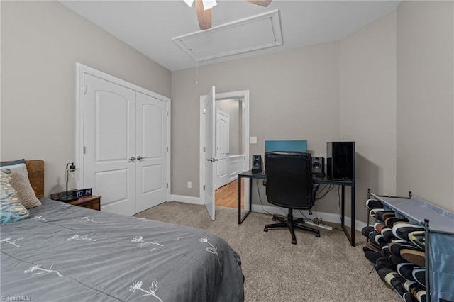 carpeted bedroom with baseboards, attic access, ceiling fan, and a closet