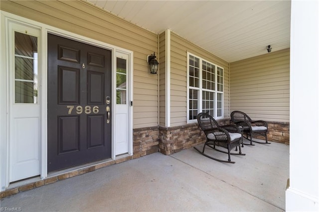 property entrance featuring covered porch and stone siding