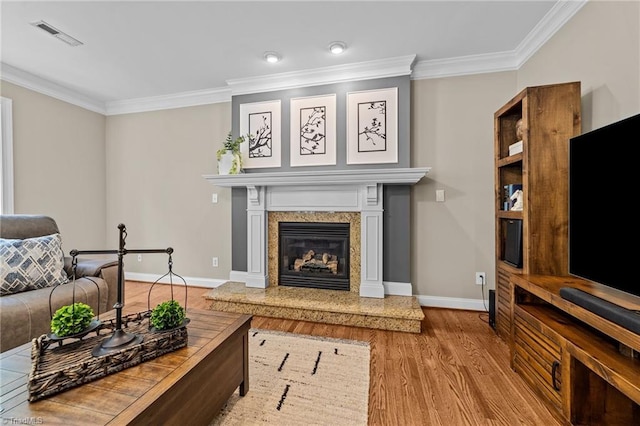 living area with visible vents, ornamental molding, baseboards, and a high end fireplace