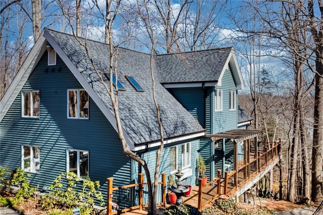 exterior space featuring stairway and roof with shingles