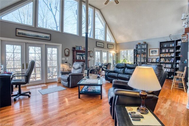 living area with high vaulted ceiling and wood finished floors