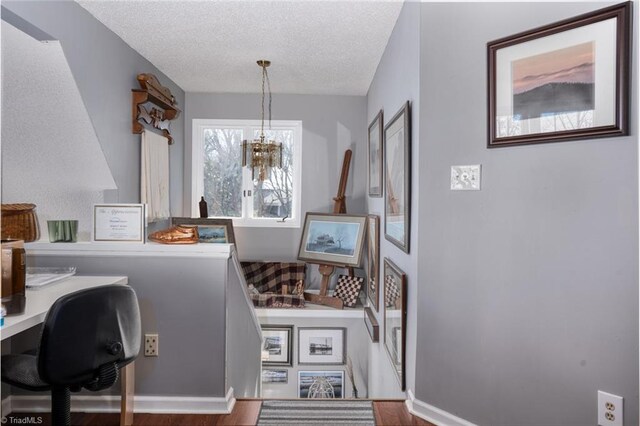 home office with baseboards, a textured ceiling, and an inviting chandelier