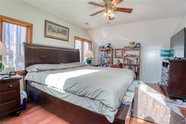bedroom with visible vents, wood finished floors, a ceiling fan, and vaulted ceiling