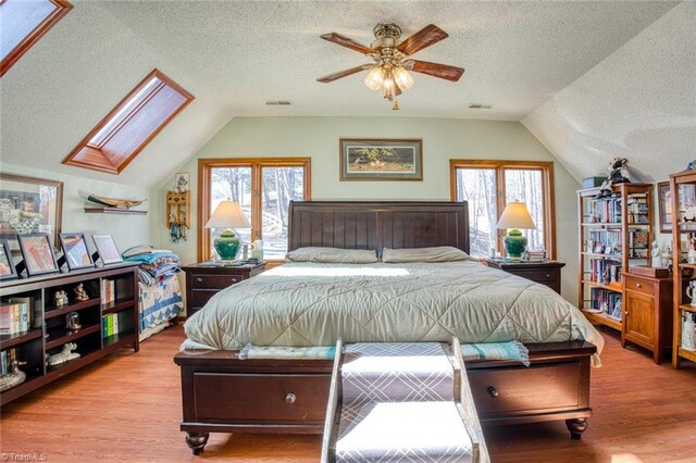 bedroom with visible vents, multiple windows, and wood finished floors