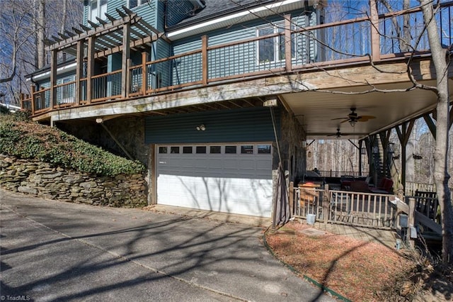 exterior space featuring driveway, a ceiling fan, and a garage