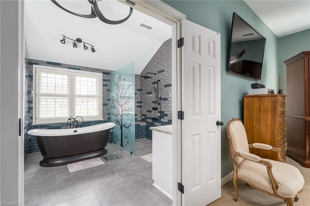 bathroom with tile patterned flooring, vaulted ceiling, and separate shower and tub