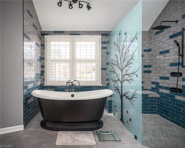 bathroom with tile patterned flooring, plus walk in shower, lofted ceiling, and tile walls