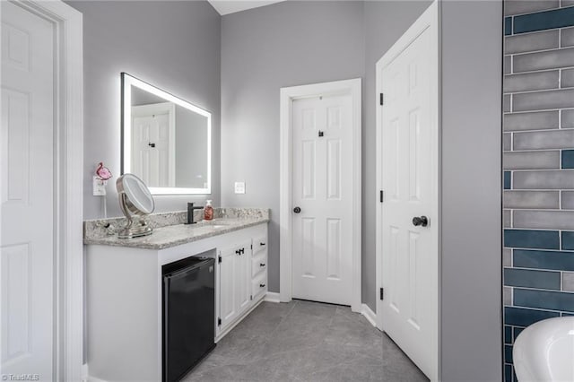 bathroom with vanity, tile patterned flooring, and a bathing tub