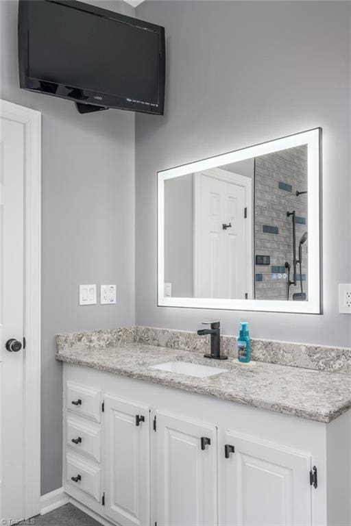 bathroom with vanity and a tile shower