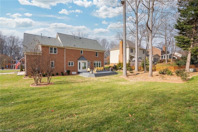 rear view of house with a deck and a lawn