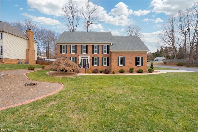 colonial inspired home featuring a front lawn