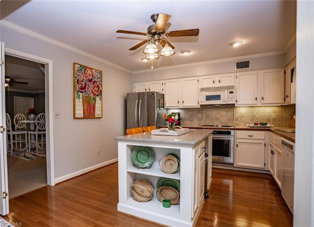 kitchen with white cabinetry, stainless steel appliances, crown molding, and a kitchen island