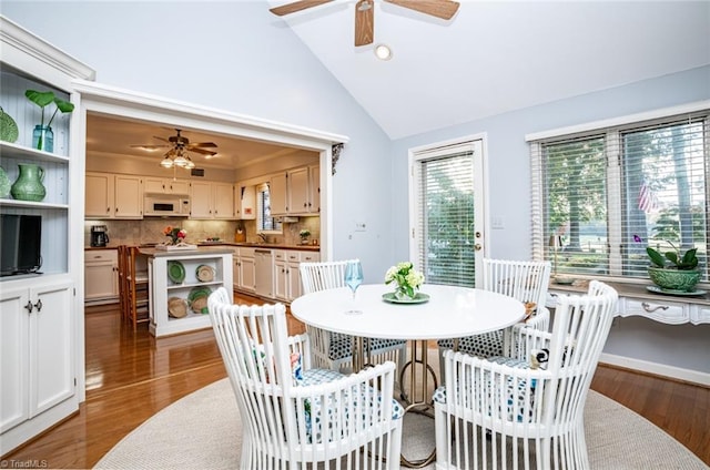 dining area featuring dark hardwood / wood-style flooring, high vaulted ceiling, and ceiling fan